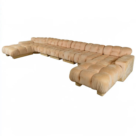 Canapé panoramique beige à assises capitonnées et lignes basses